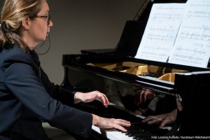 Die Pianistin Tamriko Kordzaia sitzt am Flügel und spielt konzentriert, vor ihr die aufgeschlagenen Noten.