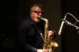 Christoph Gallio spielt Saxophon vor einem Mikrofon. Foto von John Sharpe